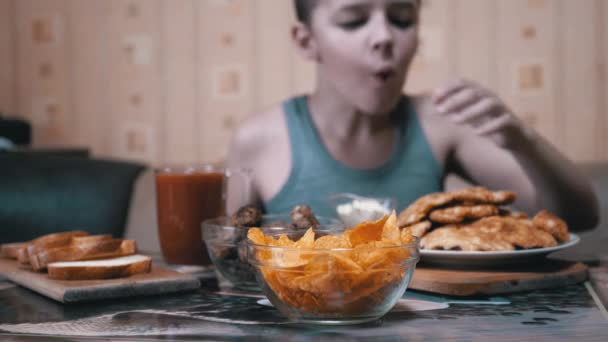 Hambriento niño mano toma crujiente de oro patatas fritas de la placa. Comida chatarra en la cena — Vídeos de Stock