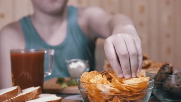 Hambriento niño mano toma crujiente de oro patatas fritas de la placa. Comida chatarra en la cena — Vídeos de Stock