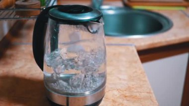 Sıcak suda kaynayan kabarcıklar içinde elektrikli su ısıtıcısı ile parlak neon ışığı