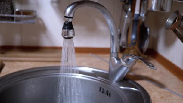 L'acqua di un rubinetto aperto nichelato scorre nel lavandino in una cucina moderna — Video Stock