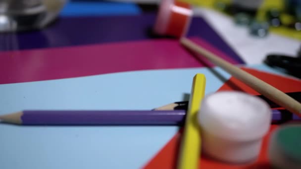 On Table are Randomly Arranged Avocarel Paints, Pencils, Brushes, Colored Paper — Stock Video