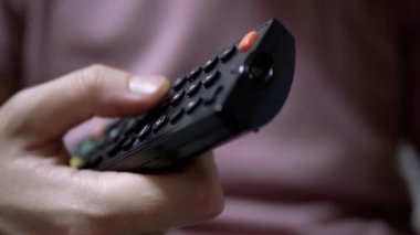 Kadın Parmaklar TV Kanallarını Siyah Uzaktan Kumanda ile Değiştirin. Yakın plan..