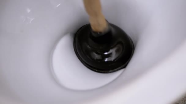 Mężczyzna czyści toaletę tłokiem pompy ręcznej. Usunięcie blokady, zanieczyszczenie — Wideo stockowe
