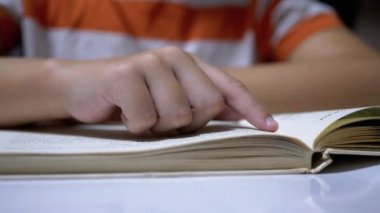 Çocuk, Parmaklarını Kitap ve Okuma Sayfası boyunca hızla koşar. Evde Uzaktan Okuma