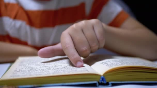 Dziecko biegnie Finger wzdłuż strony książki i czyta szybko. Czytanie zdalne w domu — Wideo stockowe