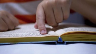 Çocuk, Parmaklarını Kitap ve Okuma Sayfası boyunca hızla koşar. Evde Uzaktan Okuma