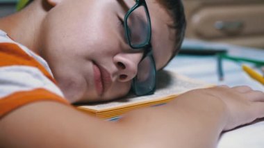 Gözlüklü Meraklı Çocuk Masa Üzerinde Kitap Okurken Uykuya daldı. Yorgunluk, uyku