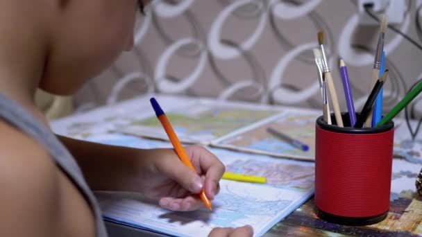 Schooljongen schrijft met linkerhand in notitieboekje, met behulp van handvat, potlood. Close-up — Stockvideo