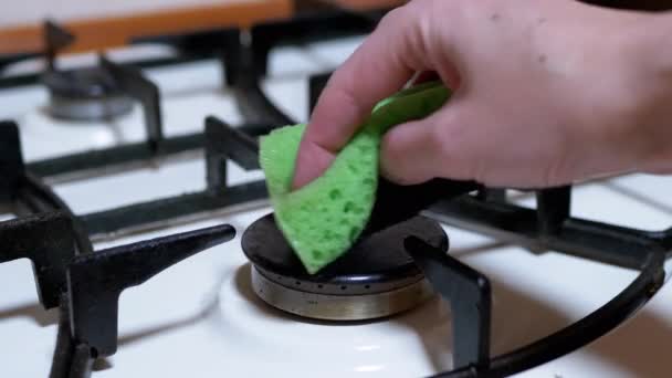 Mão feminina um limpa e limpa, lava fogão a gás, queimadores com uma esponja verde — Vídeo de Stock