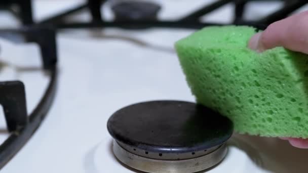 Mão feminina um limpa e limpa, lava fogão a gás, queimadores com uma esponja verde — Vídeo de Stock