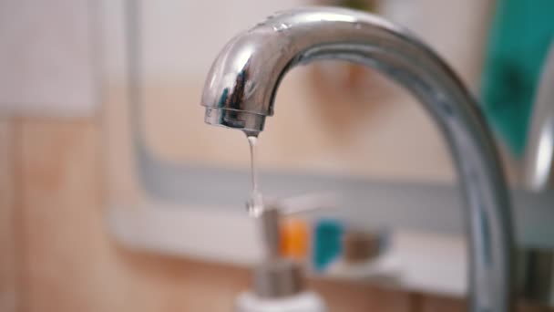 Gotas de agua fluyen lentamente hacia abajo, caen en el fregadero del grifo de agua. Fuga. — Vídeo de stock