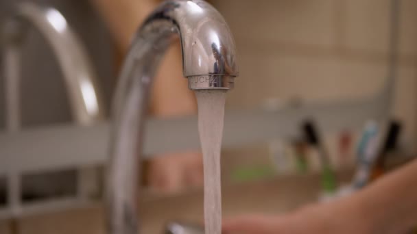 Otevřít a zavřít vodovodní kohoutek. Vysokotlaká voda teče do umyvadla v koupelně. — Stock video