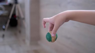 Çocuk Eli, Yeşil Topu Parmaklarıyla Tutar ve Farklı Yönlere Sallar