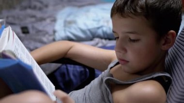 Gözlüklü Ciddi Çocuk, Sandalyeye Oturup Evde İlginç Bir Kitap Okuyor