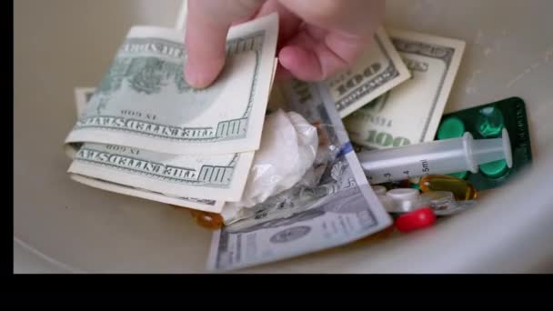 Mão masculina compra drogas para dólares, heroína no pacote, comprimidos, seringa. Fechar — Vídeo de Stock