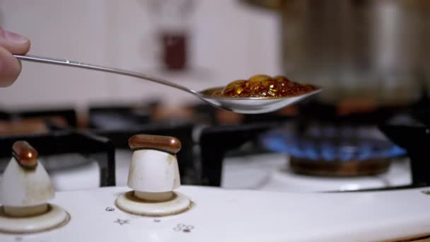 Χέρι αρσενικό Addict Μαγειρεύει Ηρωίνη στο κουτάλι πάνω από τη σόμπα αερίου στο σπίτι — Αρχείο Βίντεο
