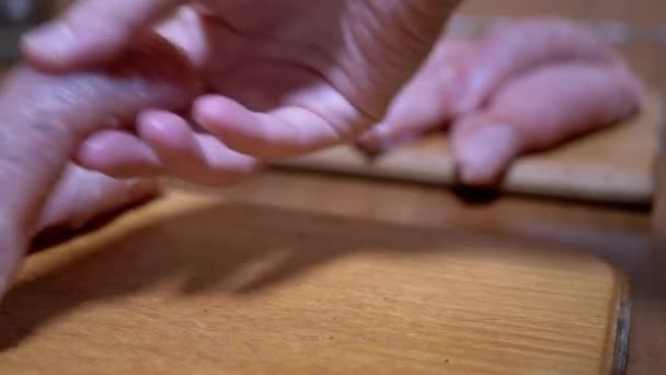 女性的手在切菜板上滚着多汁的肉卷。煮猪肉卷排骨 — 图库视频影像