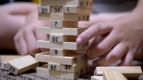 Manos chico recoger bloques de madera y jugar en el desarrollo de juego. Primer plano — Vídeos de Stock