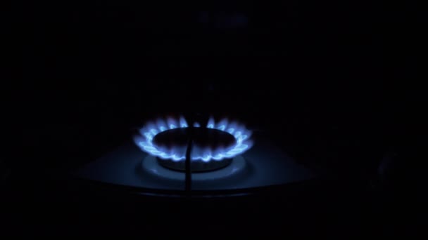 Газовая горелка включена, светится голубым пламенем, ночью на кухне. Крупный план — стоковое видео