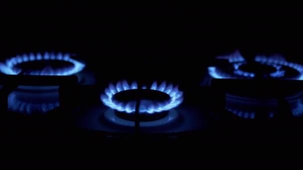 Drie gasbranders aan, gloeiend met blauwe vlam, 's nachts in de keuken. Close-up — Stockvideo