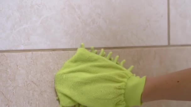 緑のマイクロファイバーミットで円運動中の女性の手のワイプバスルームタイル — ストック動画