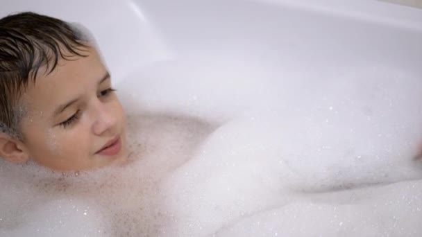 Baños de niño en el baño con espuma, Juega con burbujas de espuma jabonosa, Niño feliz — Vídeos de Stock