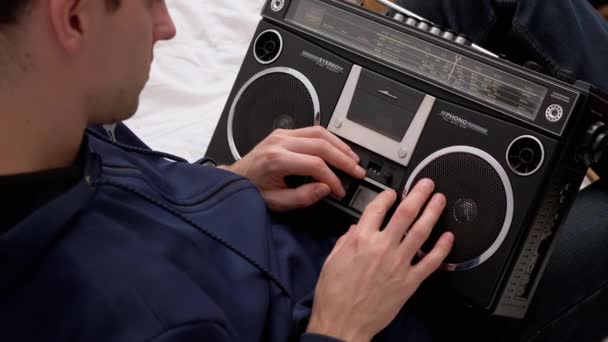 Hombre sosteniendo una vieja grabadora de audio retro, examinando de cerca, toca con los dedos — Vídeo de stock