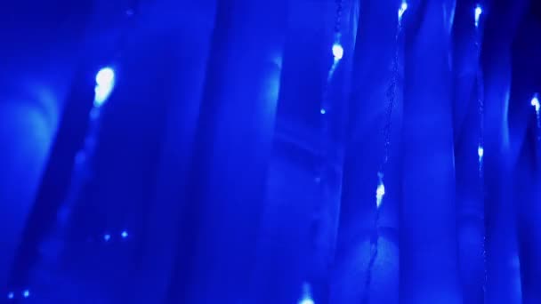 许多闪烁的圣诞花环，在窗帘上挂着蓝色LED灯。变焦 — 图库视频影像