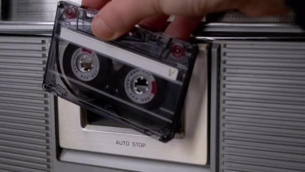 女性の手で古い透明カセットを回転させ、テープレコーダーに挿入します。4K — ストック動画