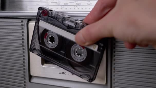 Kvinnlig hand roterar gammal kassett 90-talet nära grå vintage mottagare. Närbild. 4K. — Stockvideo