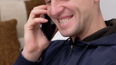 Gülümseyen ve Diş Gösteren Cep Telefonu 'nda Mutlu Erkek Konuşmaları. Büyüt