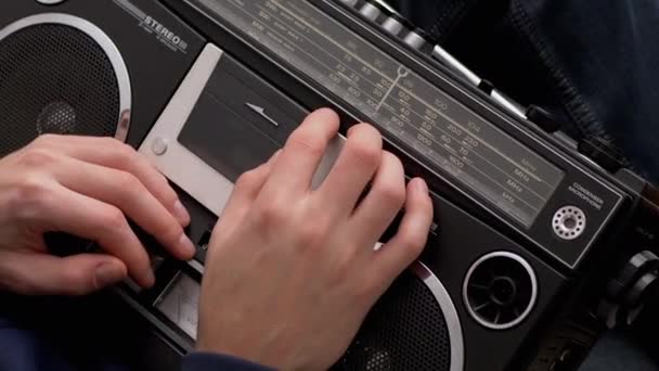 Männchen hält altes Tonbandgerät mit Magnetkassette in den Händen — Stockvideo