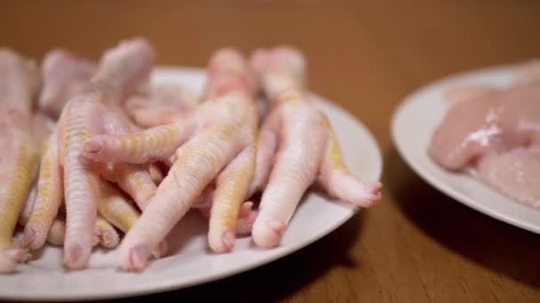 Φρέσκα πιόνια κοτόπουλου, φιλέτα, φτερά ξαπλωμένα σε πιάτα. 4K. Κοντινό πλάνο. Κουζίνα στο σπίτι — Αρχείο Βίντεο