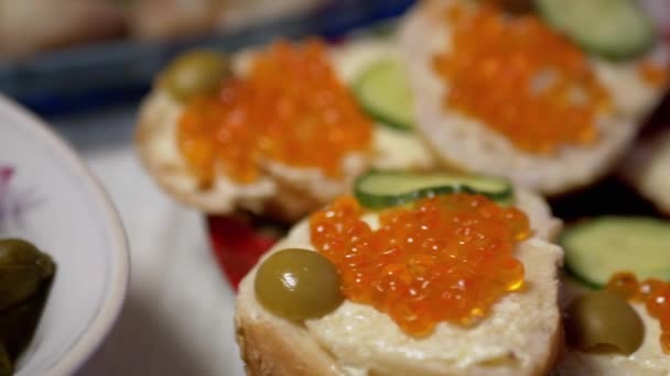 Feestelijke gerechten op tafel: sandwiches met rode kaviaar, augurken. Zoom — Stockvideo
