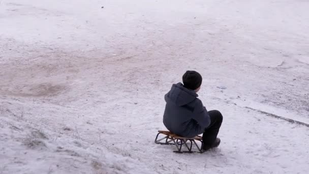 Happy Boy Sledding Down White Hill em Winter in Yard. Zoom — Vídeo de Stock