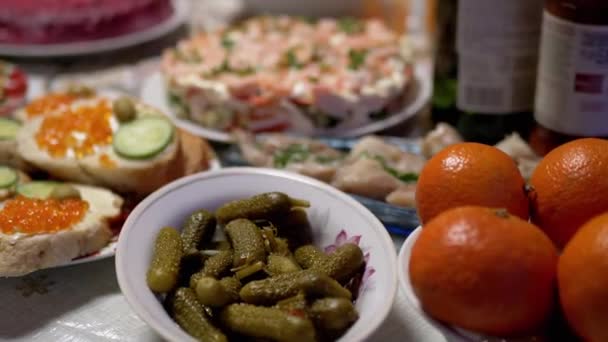 Feestelijke gerechten op tafel: broodjes met rode kaviaar, salade, mandarijnen, augurken — Stockvideo