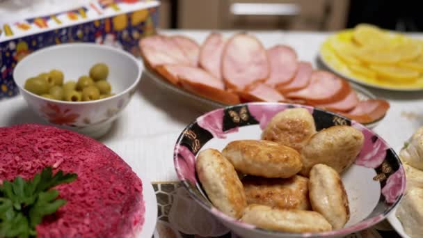 Platos festivos en la mesa: Ensalada de camarones, Ensalada Shuba. Pescado, Carne, Aceitunas, Chuletas — Vídeo de stock