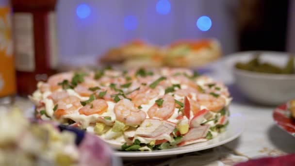 Piatti celebrativi in tavola: insalata di gamberetti, sfondo sfocato con ghirlanda. 4K — Video Stock