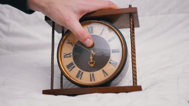 Mão masculina detém vintage clássico relógio de mesa de madeira com numerais romanos. 4K — Vídeo de Stock