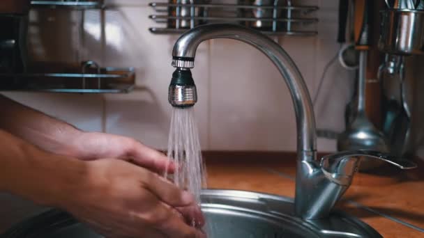 Männliche Hände unter einem starken Wasserstrahl waschen. Platsch. Wasser läuft aus dem Hahn — Stockvideo