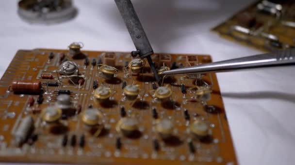 Transístores Man Unsolders, Peças de rádio na placa eletrônica com ferro de solda — Vídeo de Stock