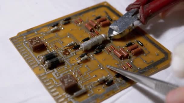 Master with Wire Cutters Disconnecting Radio Parts, Resistors from Board, Scheme — Stock video