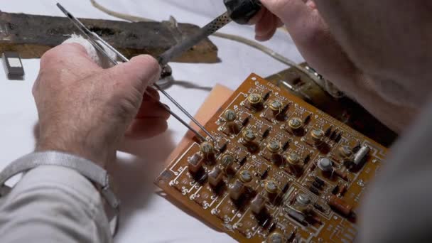 Man Solders Transistors, Radio-onderdelen op elektronisch bord met soldeerbout. — Stockvideo