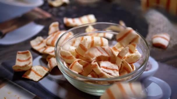 Аппетитные Жареные картофельные чипсы с беконом, падающим в стеклянную чашу на столе — стоковое видео