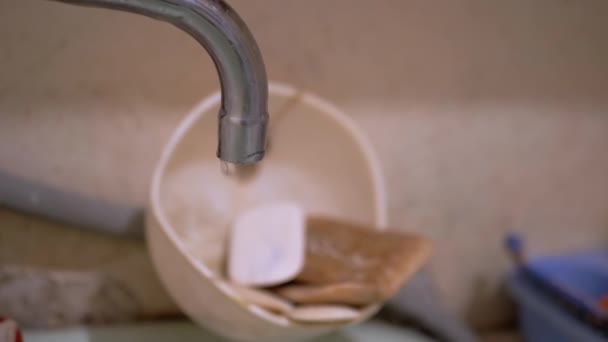L'eau coule dans l'évier du vieux robinet d'eau dans la salle de bain. Fuite d'eau. 4K — Video