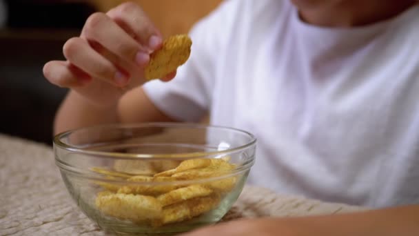 Jungen Hand nimmt Cracker von einem Teller. Schädliche Snacks essen. Fast Food — Stockvideo
