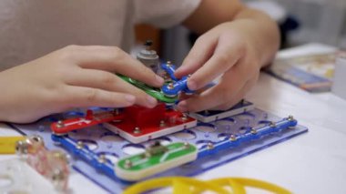 Meraklı Çocuk Metal İnşaat Malzemeleri Elektrik Devresini Birleştiriyor. Büyüt