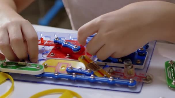 Curious Boy ensambla piezas del kit de construcción de circuitos eléctricos de metal. Zoom: — Vídeos de Stock