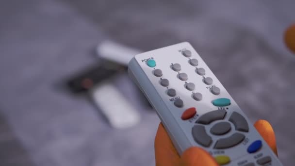 Dámské ruce v gumových rukavicích utírá TV dálkové ovládání s bavlněným podložkou a sprejem — Stock video