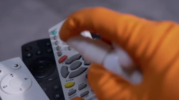 Las manos femeninas en guantes de goma limpian el control remoto de TV con almohadilla de algodón y aerosol — Vídeo de stock